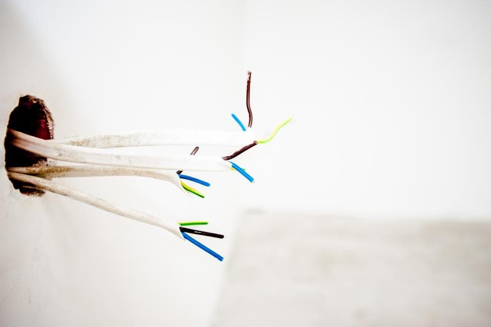 Electrical cables coming out of a wall waiting for a switch or socket