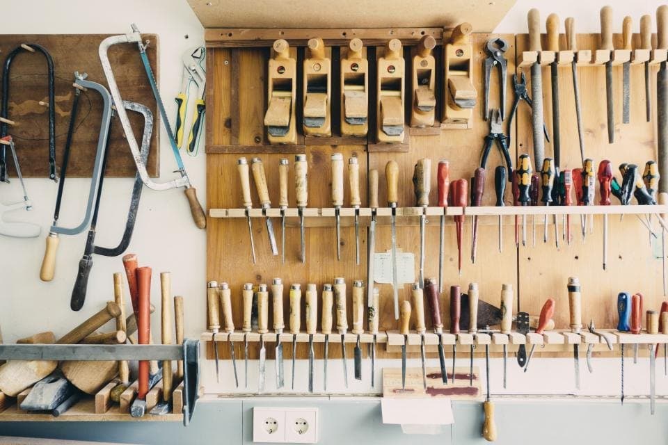 Hand tools neatly organised on a workshop wall