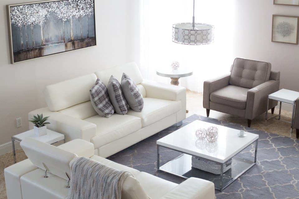 Well-kept living room with white sofas and a chandelier