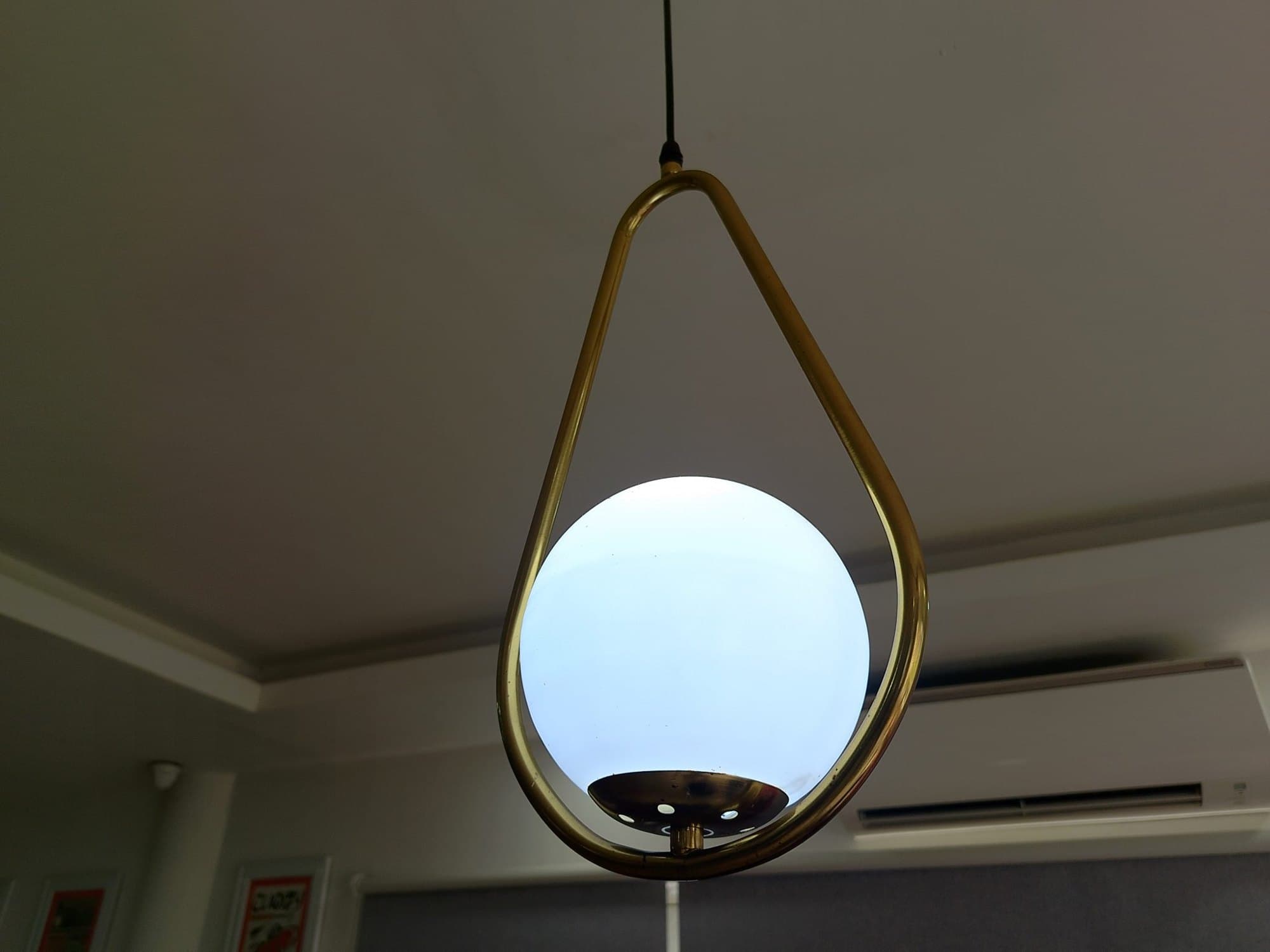 Globe pendant light in a room with a wall-mounted split AC unit