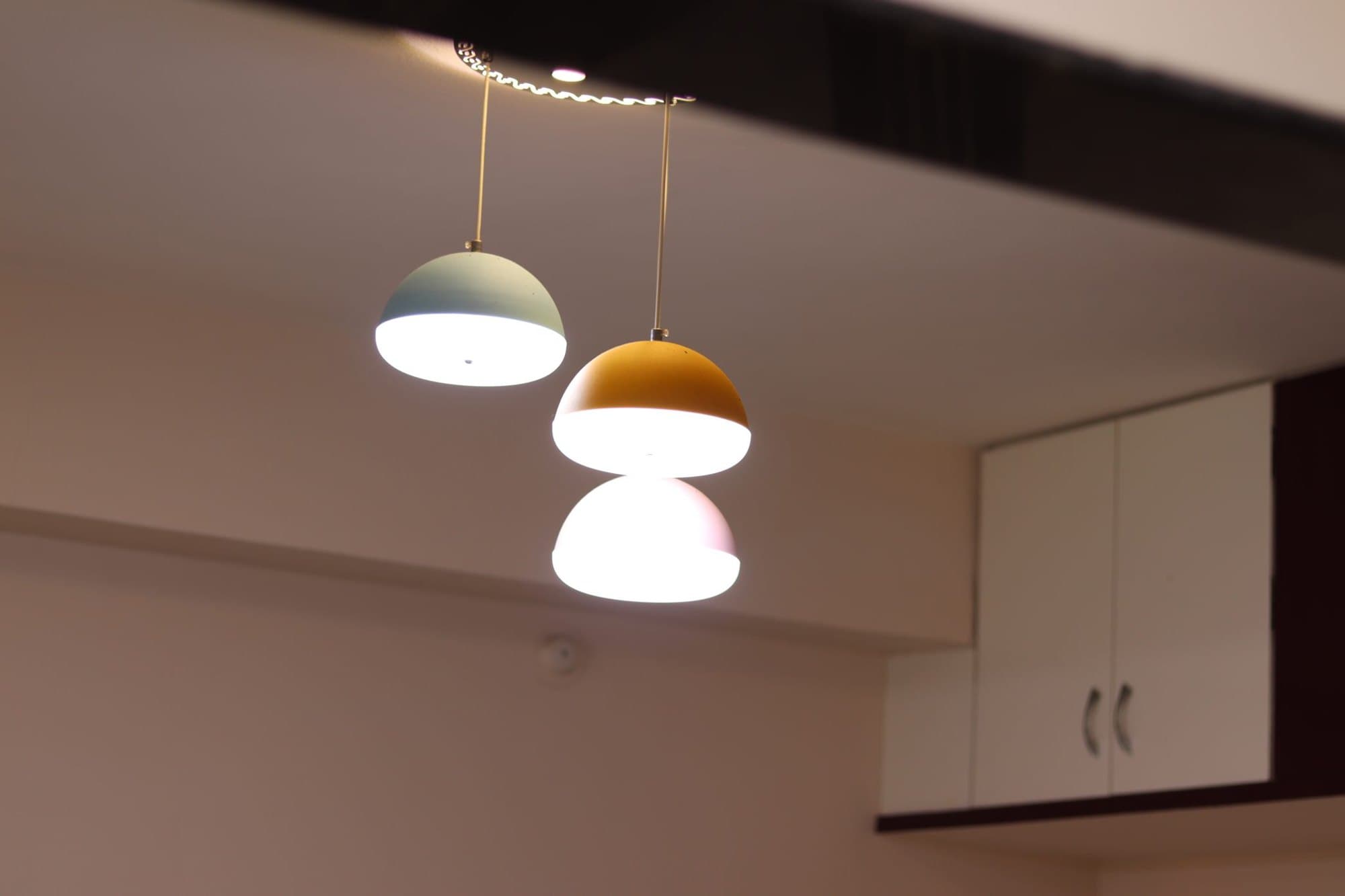 Three modern pendant lights hanging over a kitchen counter