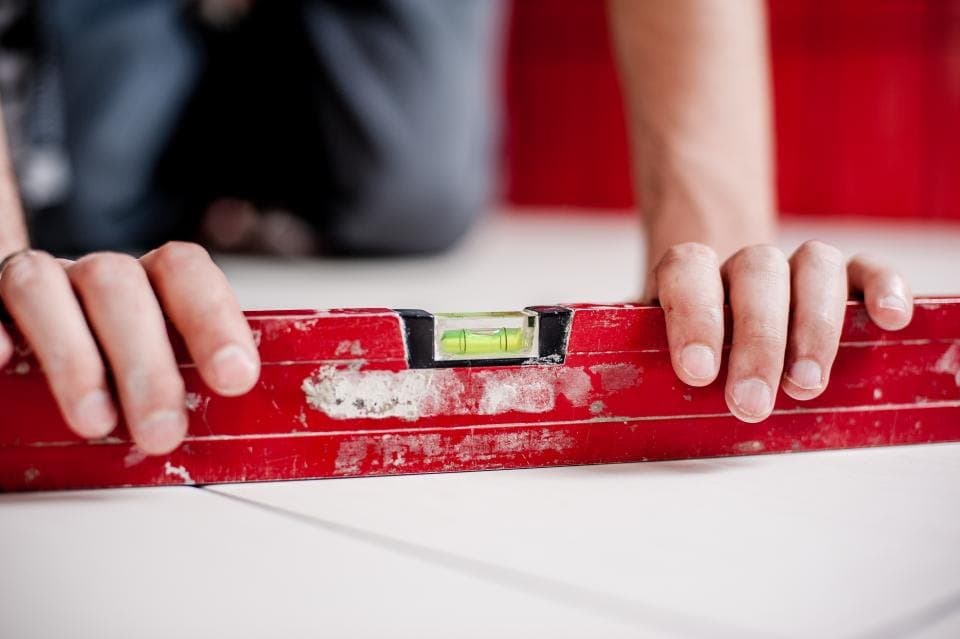 Technician checking a surface with a red spirit level